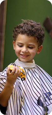 Criança sorrindo durante o corte